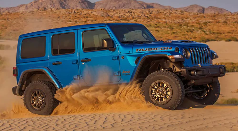 A blue 2021 Jeep Wrangler Rubicon 392 off-roading in the desert.
