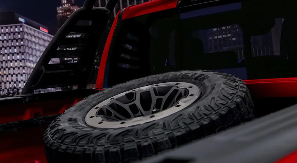 Close-up of the spare tire in the bed of a red 2022 Ram 1500 TRX.