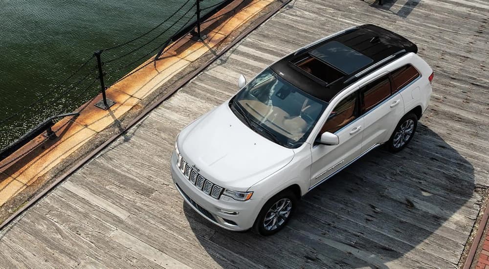 Birds-eye view of a white 2021 Jeep Grand Cherokee parked on a wharf.
