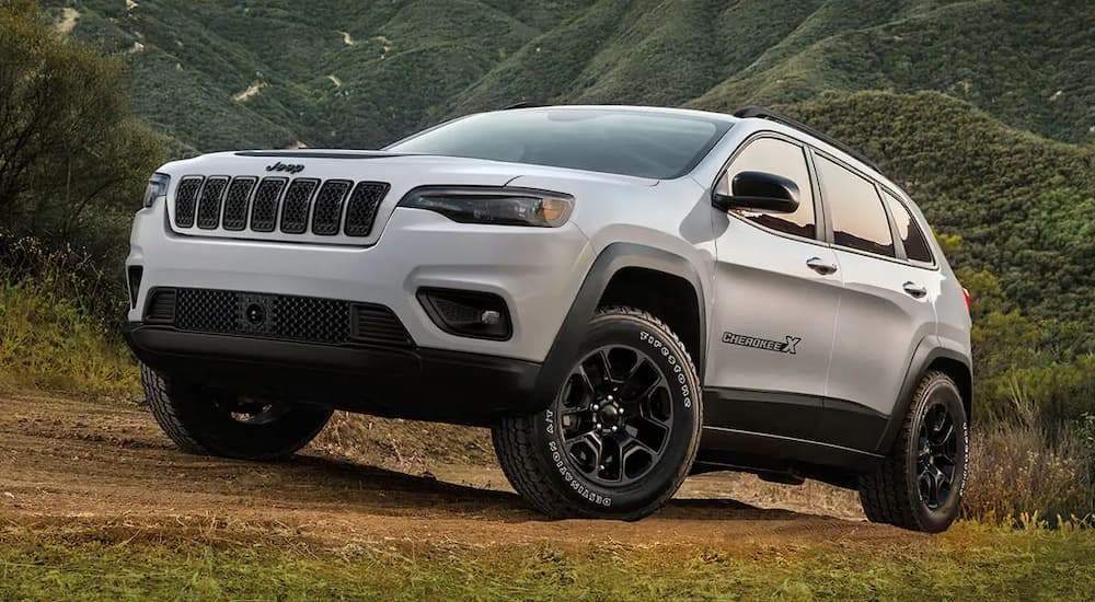 A white 2022 Jeep Cherokee X parked on a hilly trail.