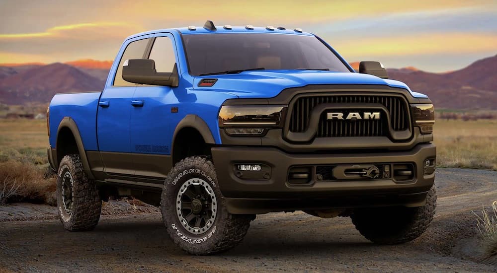 A blue 2022 RAM 2500 Power Wagon parked in the desert at sunset