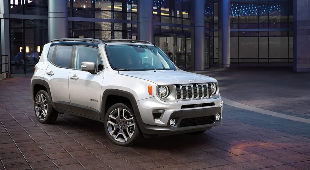 A silver 2021 Jeep Renegade Limited parked in front of an illuminated building