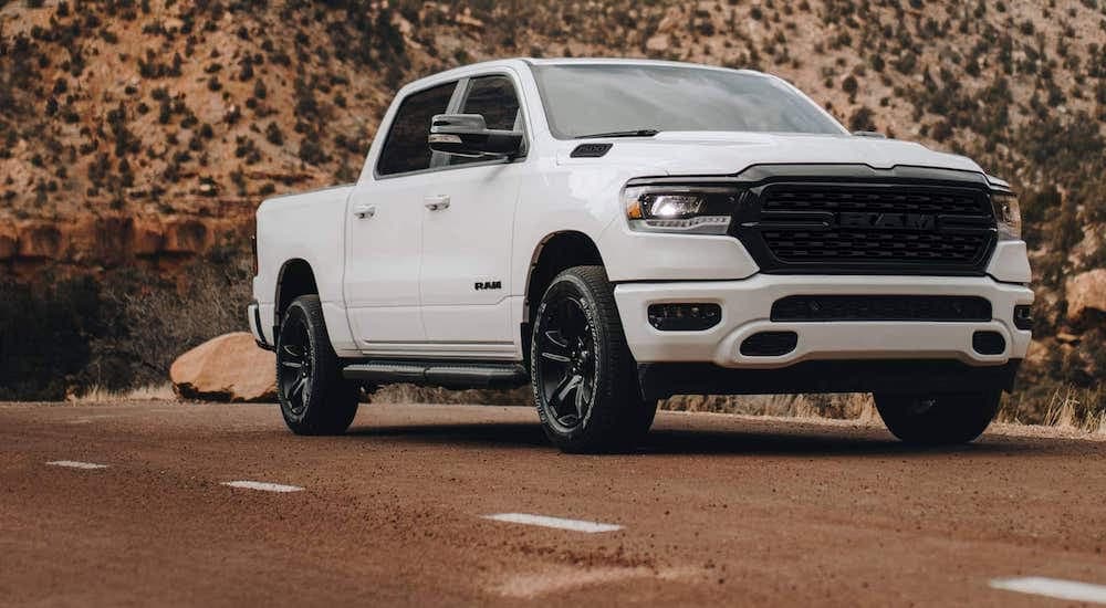 A white 2022 Ram 1500 driving on a desert road