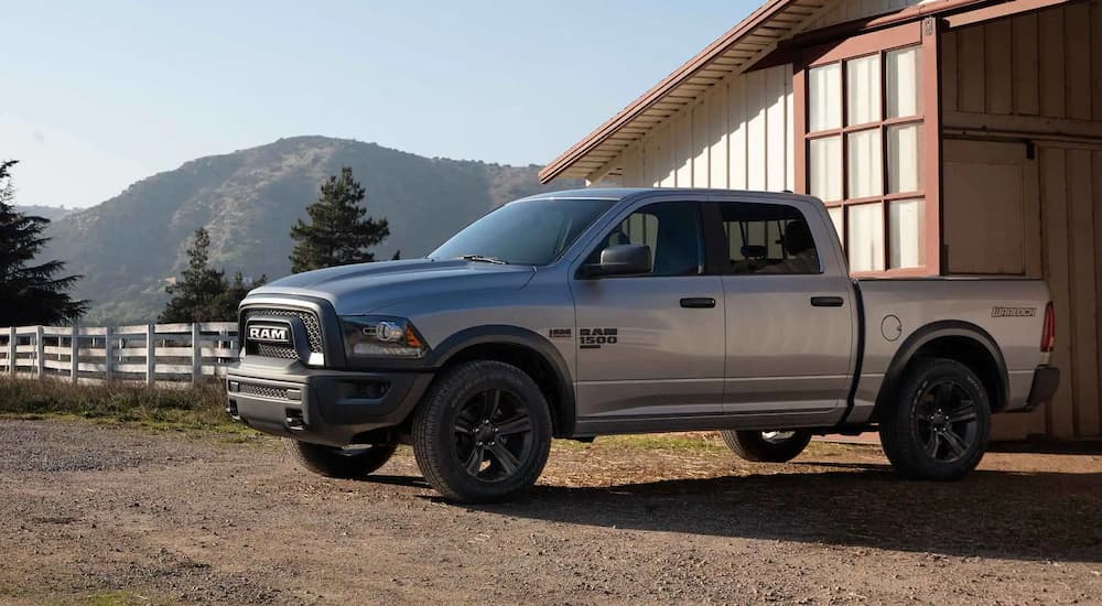 A grey 2022 Ram 1500 Classic Warlock parked outside of a barn.
