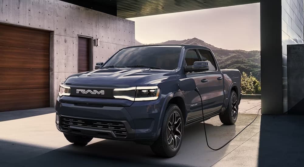 A blue 2024 Ram 1500 REV is shown from the front while charging