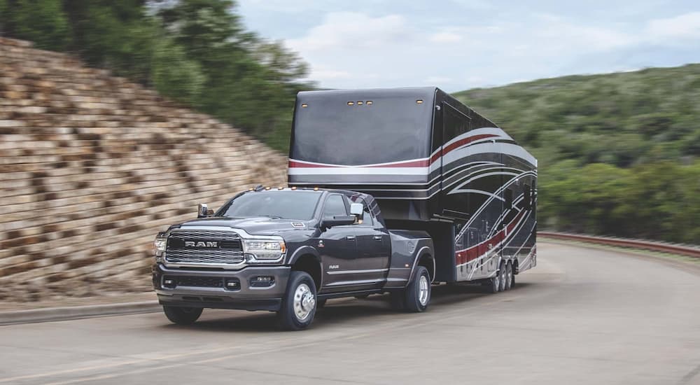 A 2023 Ram 3500 is shown from the front while towing a camper.