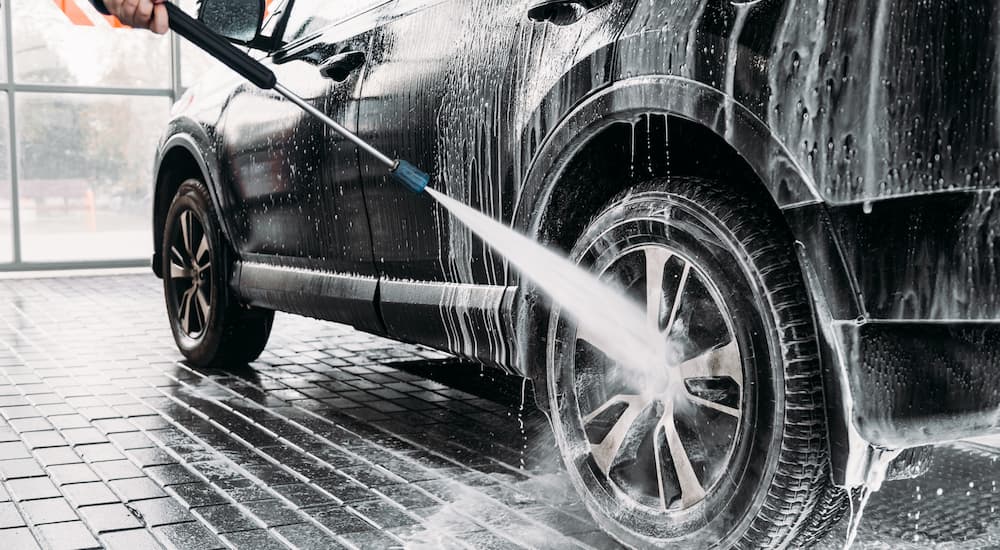 A vehicle is shown being cleaned at a car wash.