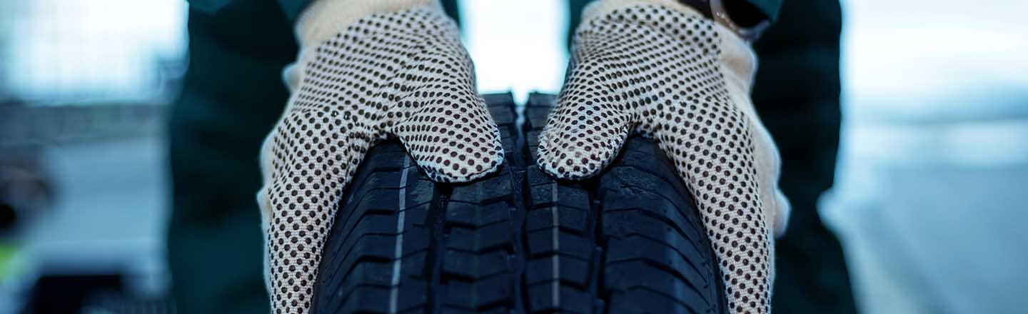 Close up of gloved hands on a new tire