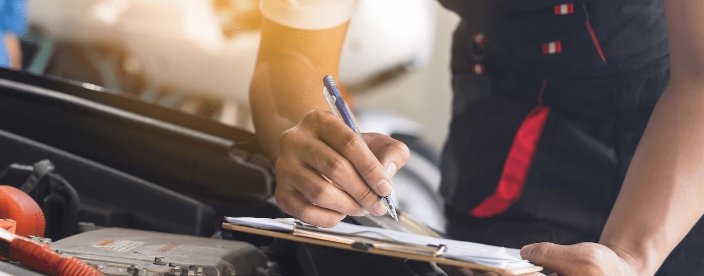 A mechanic is shown checking out paperwork for a car recall.