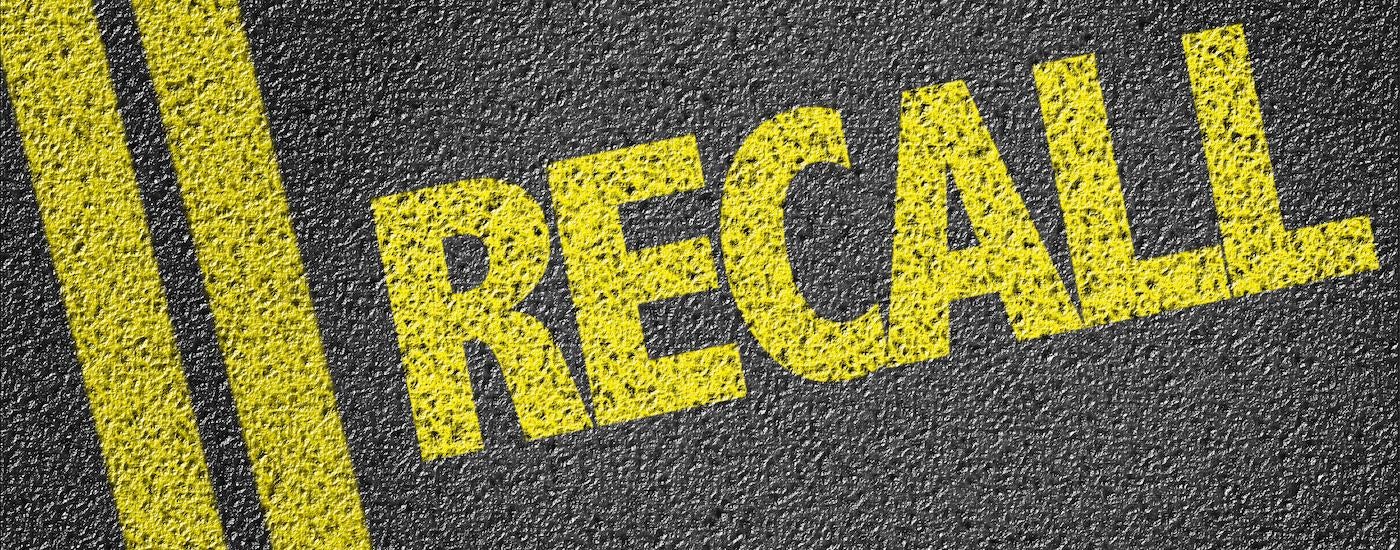 A road is shown with the word 'recall' painted on it.