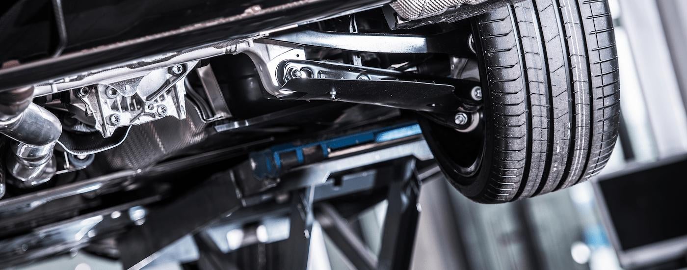 A vehicle is shown on a lift during a vehicle recall repair.