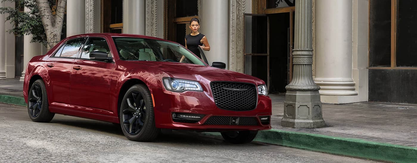 A red 2021 Chrysler 300 Touring L is shown parked on the side of a city street.