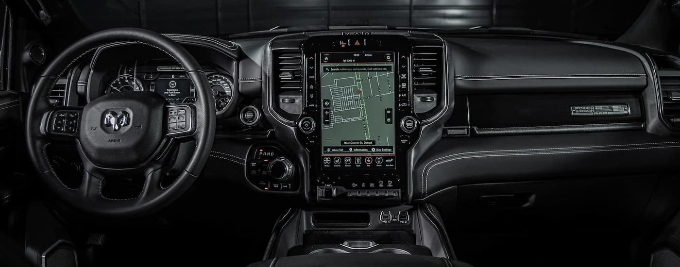 The black interior of a 2021 Ram 2500 Power Wagon shows the steering wheel and infotainment screen.