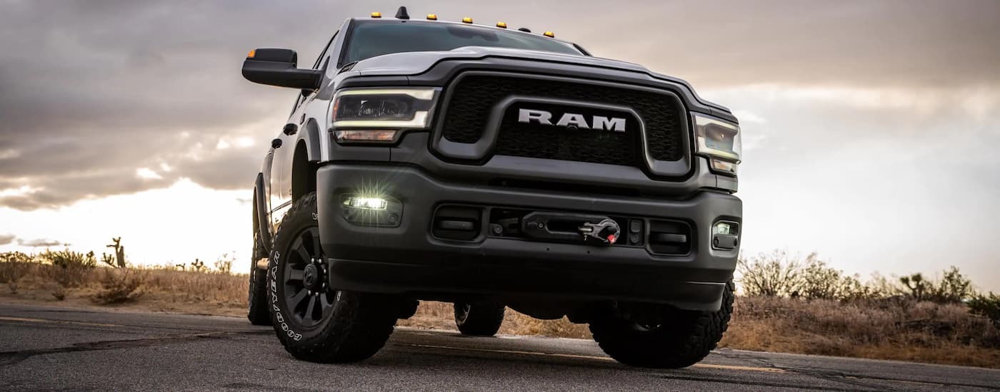 A close up shows a silver 2021 Ram 2500 Power Wagon parked in an empty paved lot after leaving a certified pre-owned Ram dealer.