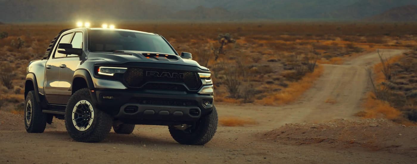A silver 2021 Ram 1500 TRX is shown parked at the end of a dirt path.