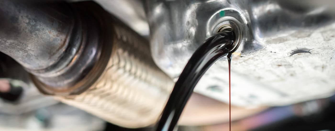 Oil is shown draining from an engine after an oil change service.