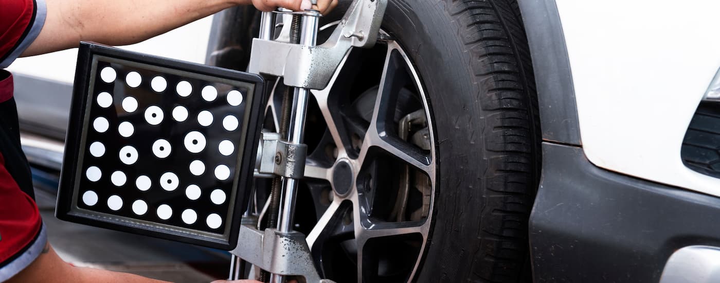 A mechanic is shown performing a tire alignment.